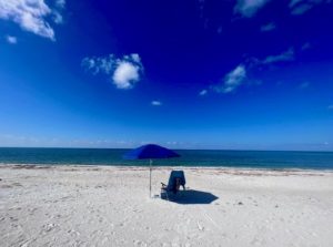 Blue umbrella and beach chair alone on Safety Harbor Club Beach Upper Captiva, FL